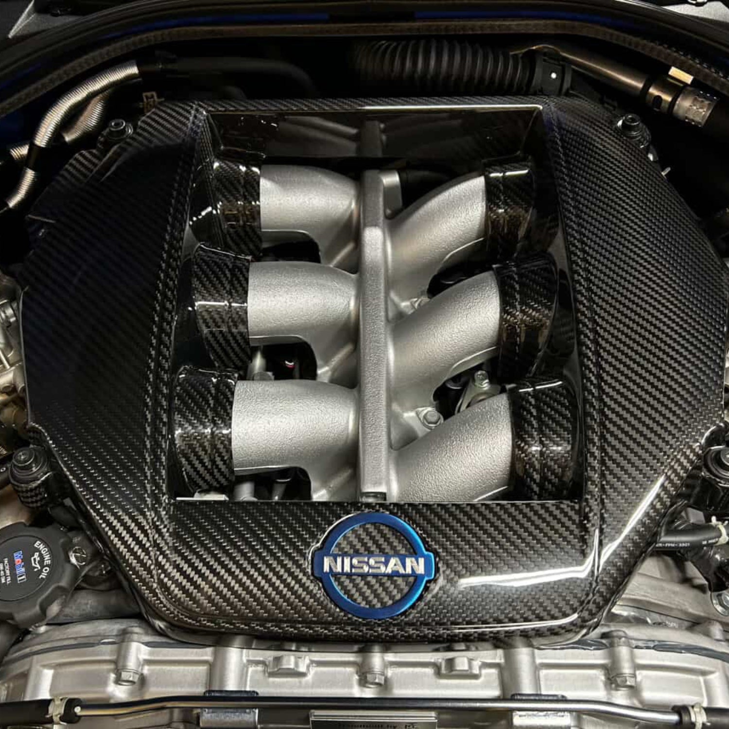 Nissan engine with carbon fiber cover and visible logo