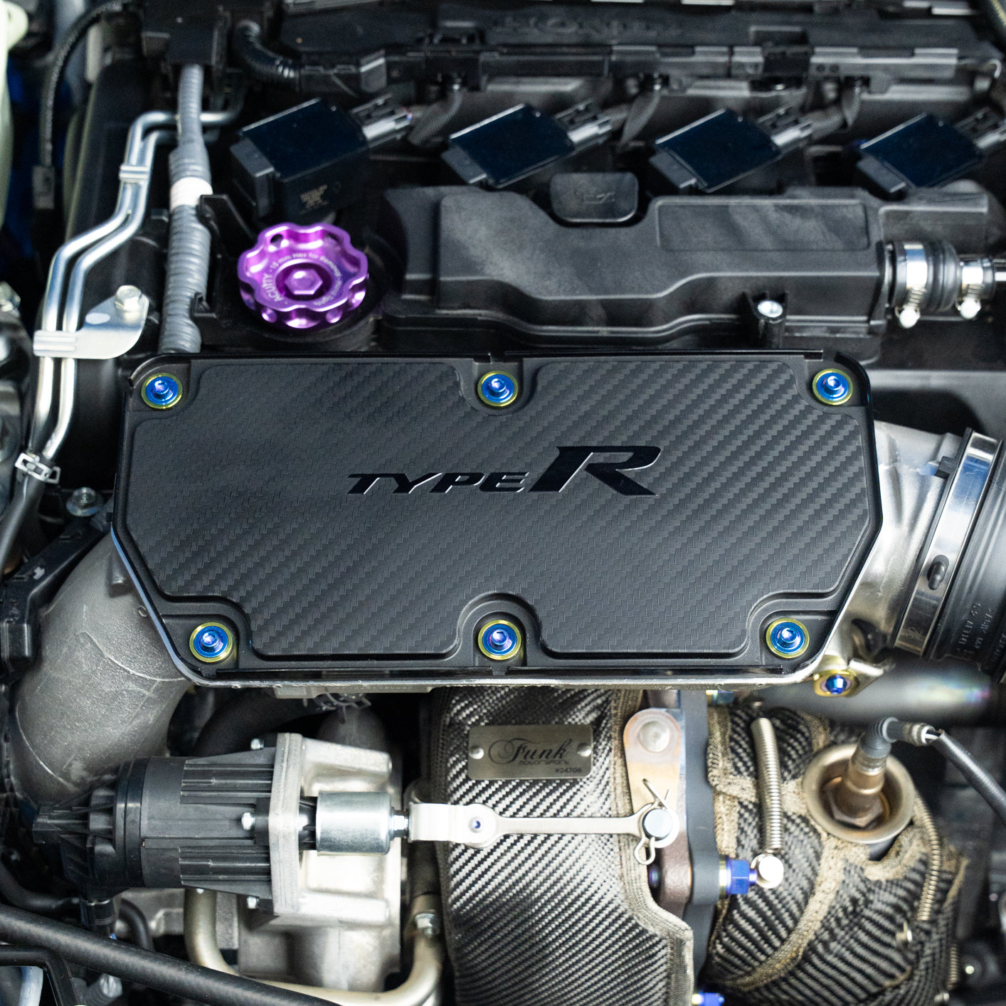 Car engine with 'TYPE R' cover showing titanium hardware