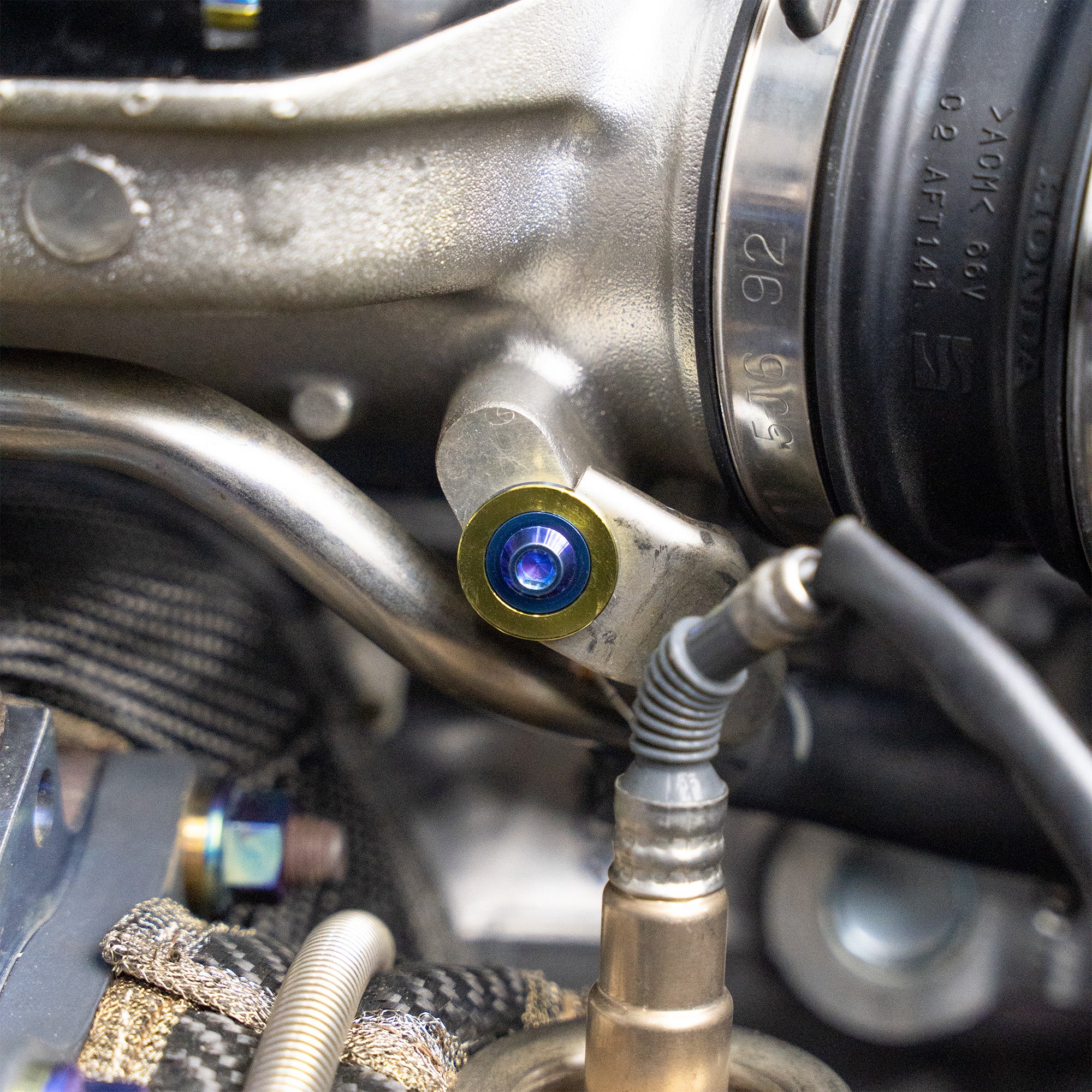 Close-up of a mechanical component with a blue bolt on a vehicle engine.