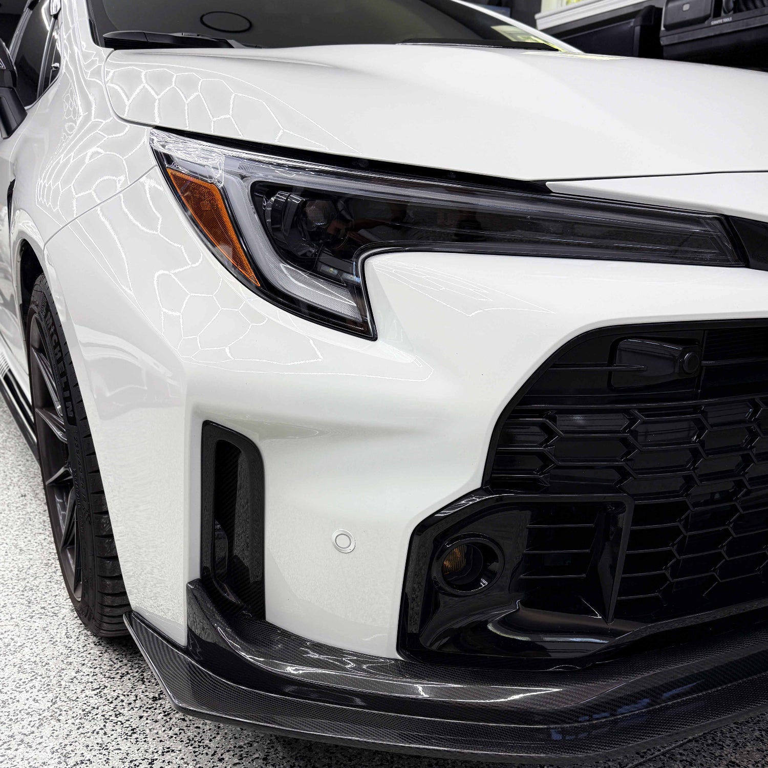 Close-up of a white Toyota GR Corolla front bumper air ducts.