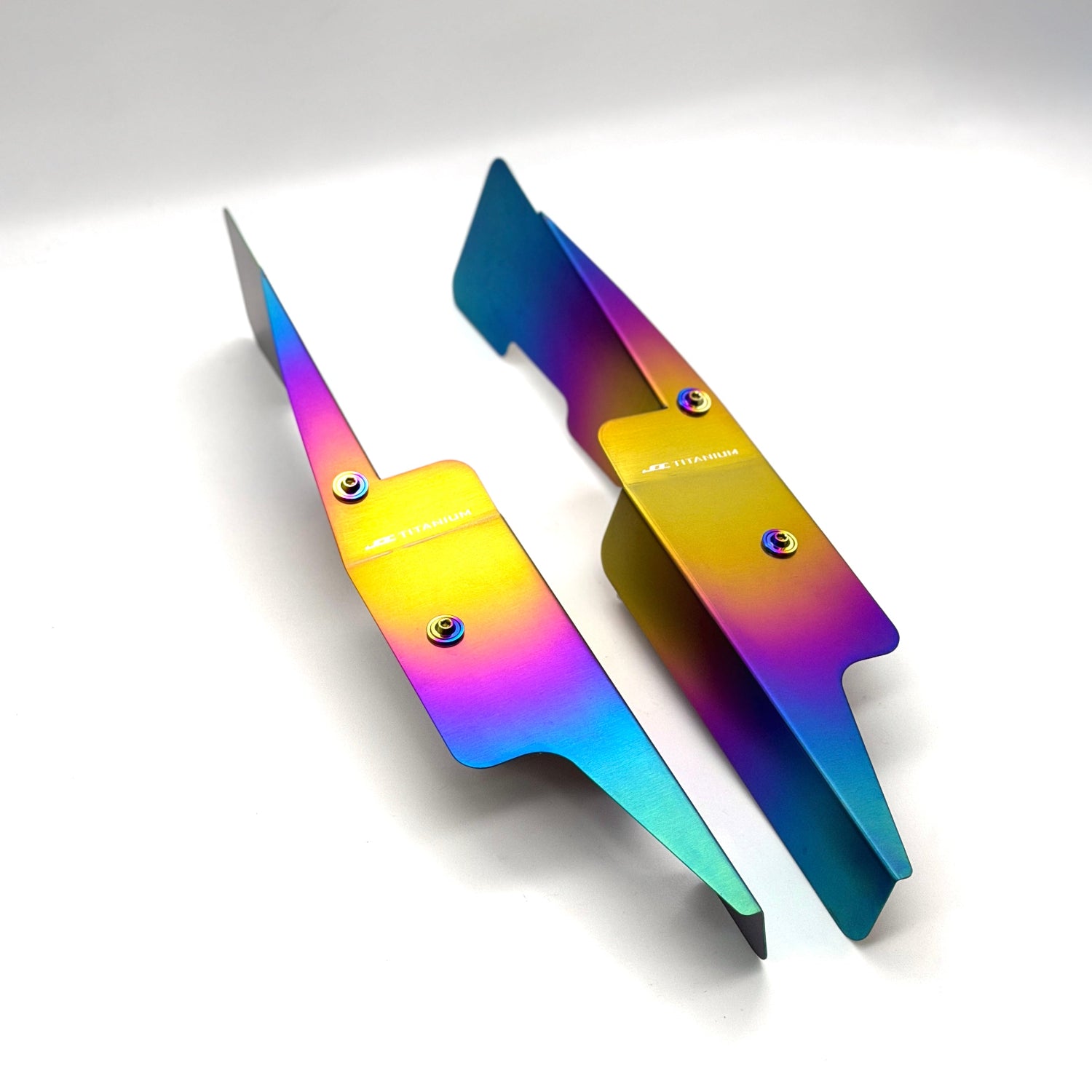 JDC Titanium fender shroud for 2023-2025 Toyota GR Corolla in a Freaktanium gradient finish with matching titanium hardware on a white background