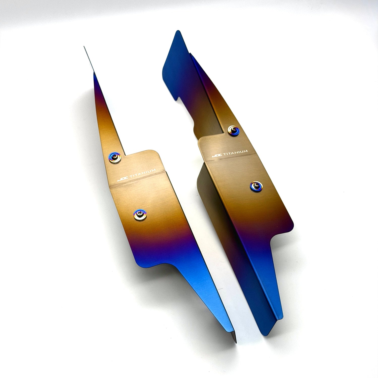 JDC Titanium fender shroud for 2023-2025 Toyota GR Corolla in a Burnt gradient finish with matching titanium hardware on a white background