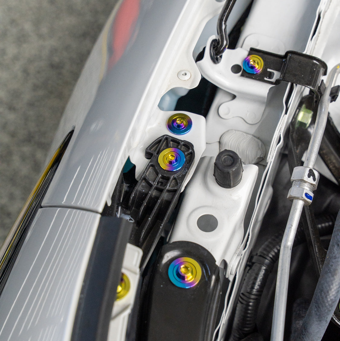 Gradient freaktanium titanium hardware installed on a white Acura Integra A-Spec