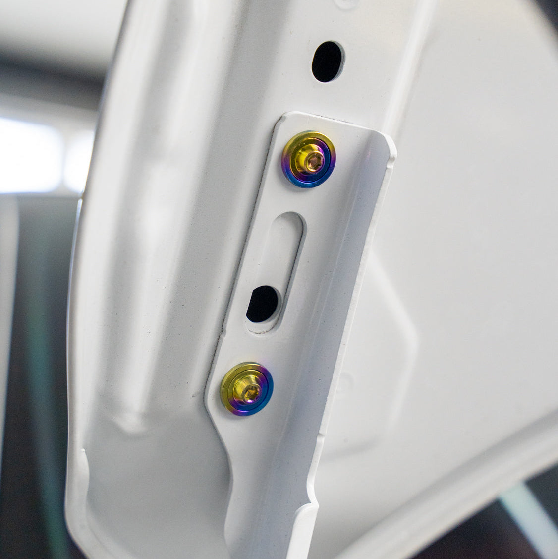 Gradient freaktanium titanium hardware installed on a white Acura Integra A-Spec Hood bracket