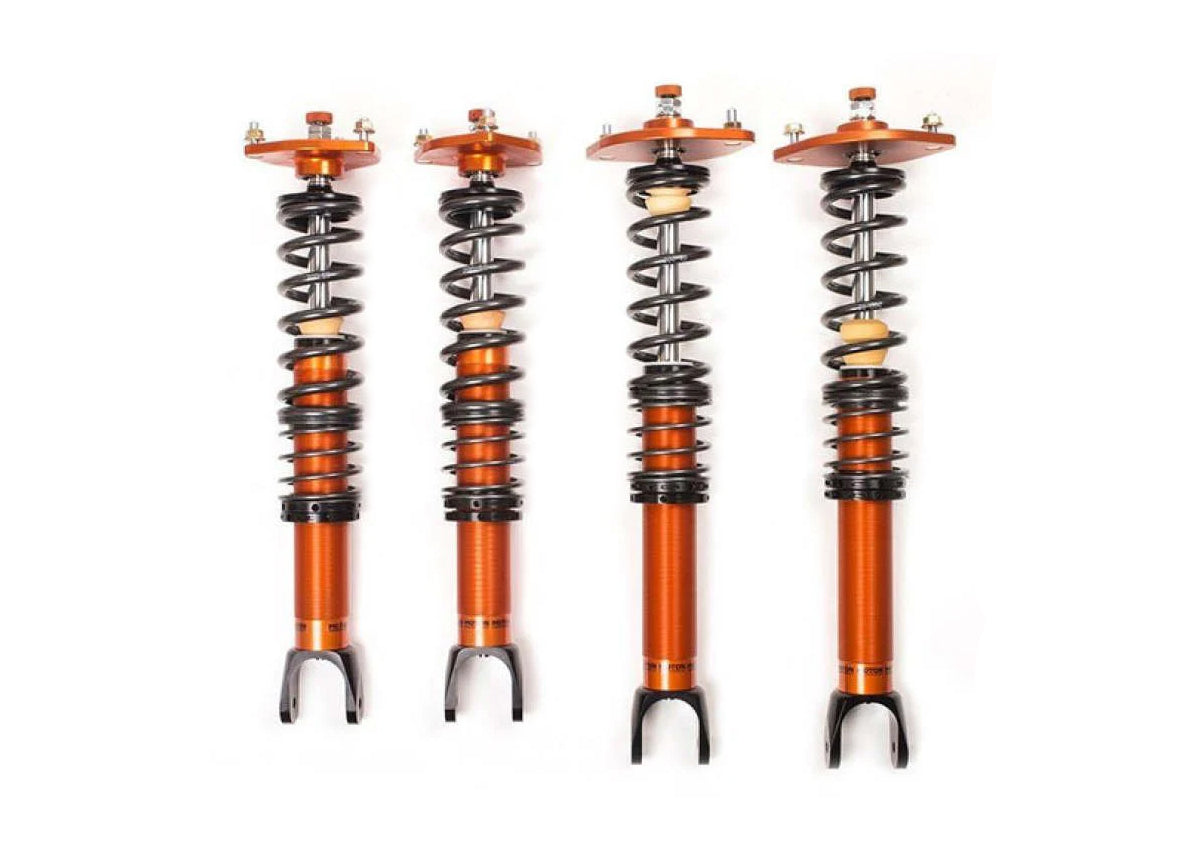 Four Orange Coilovers on a white background