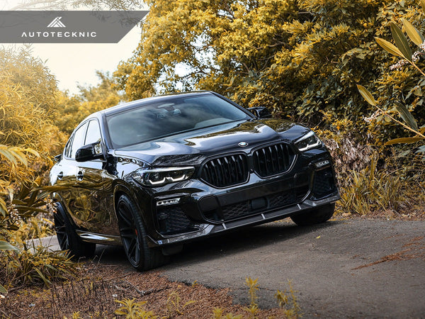 Grey BMW Driving On Path With Foliage Behind it