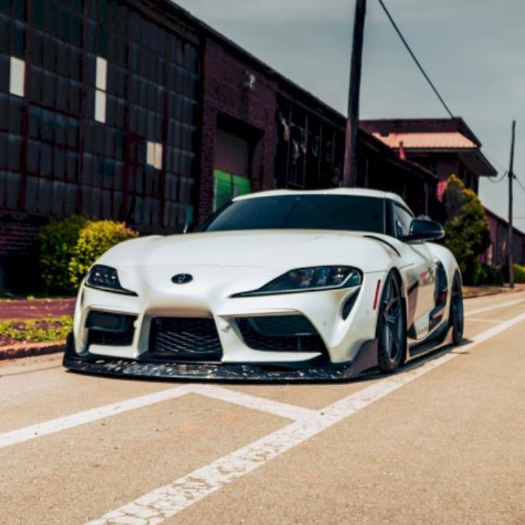White A90 Supra With Industrial Backdrop Behind It