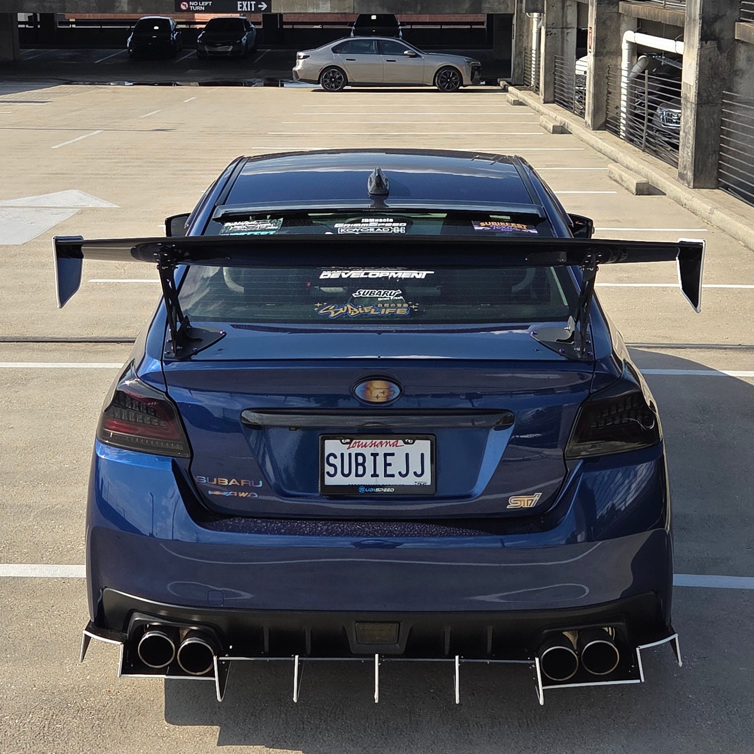 Rear angle of a 2015 Subaru STi with JDC Titanium Badges in a burnt gradient color. 