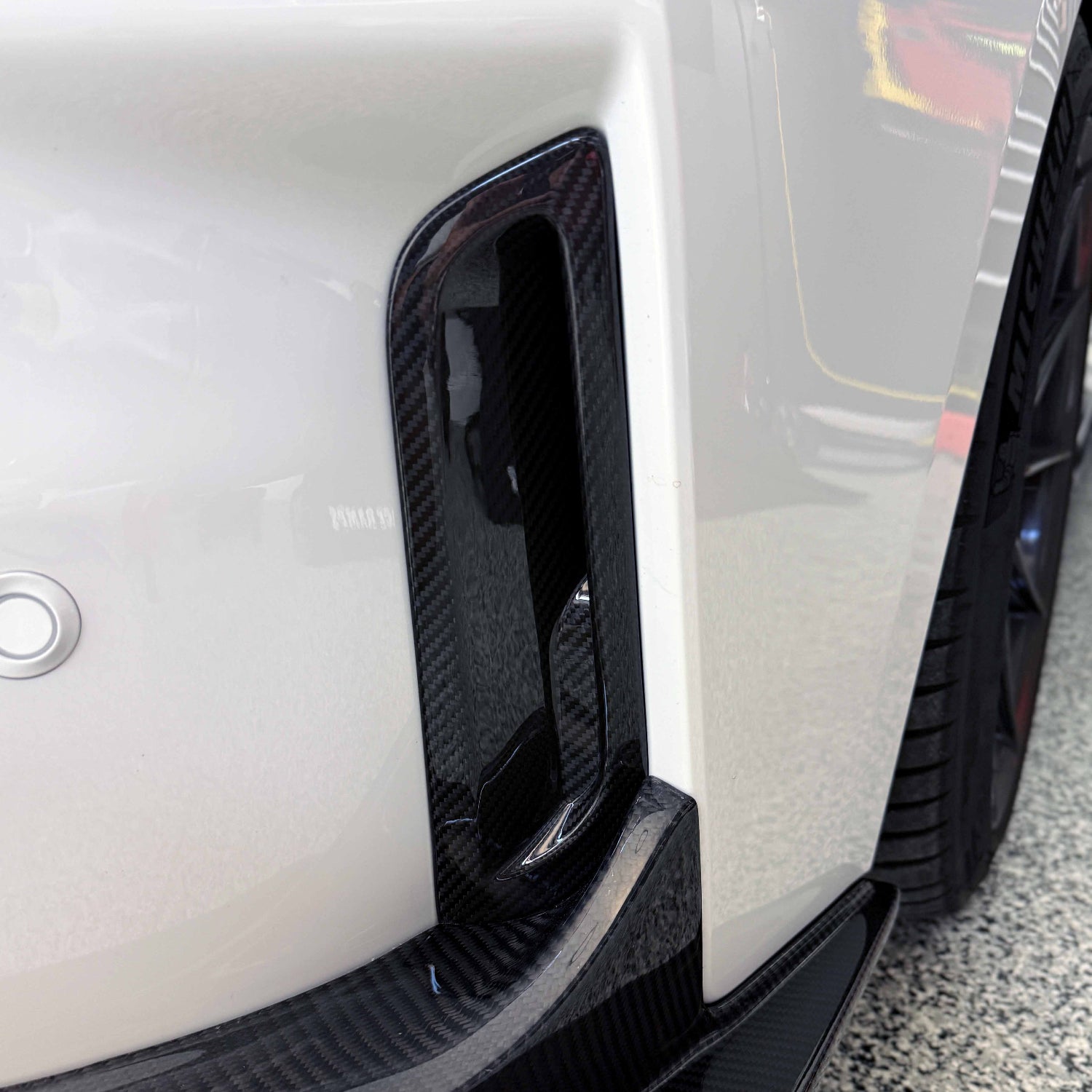 Close-up of a white Toyota GR Corolla front bumper air ducts.