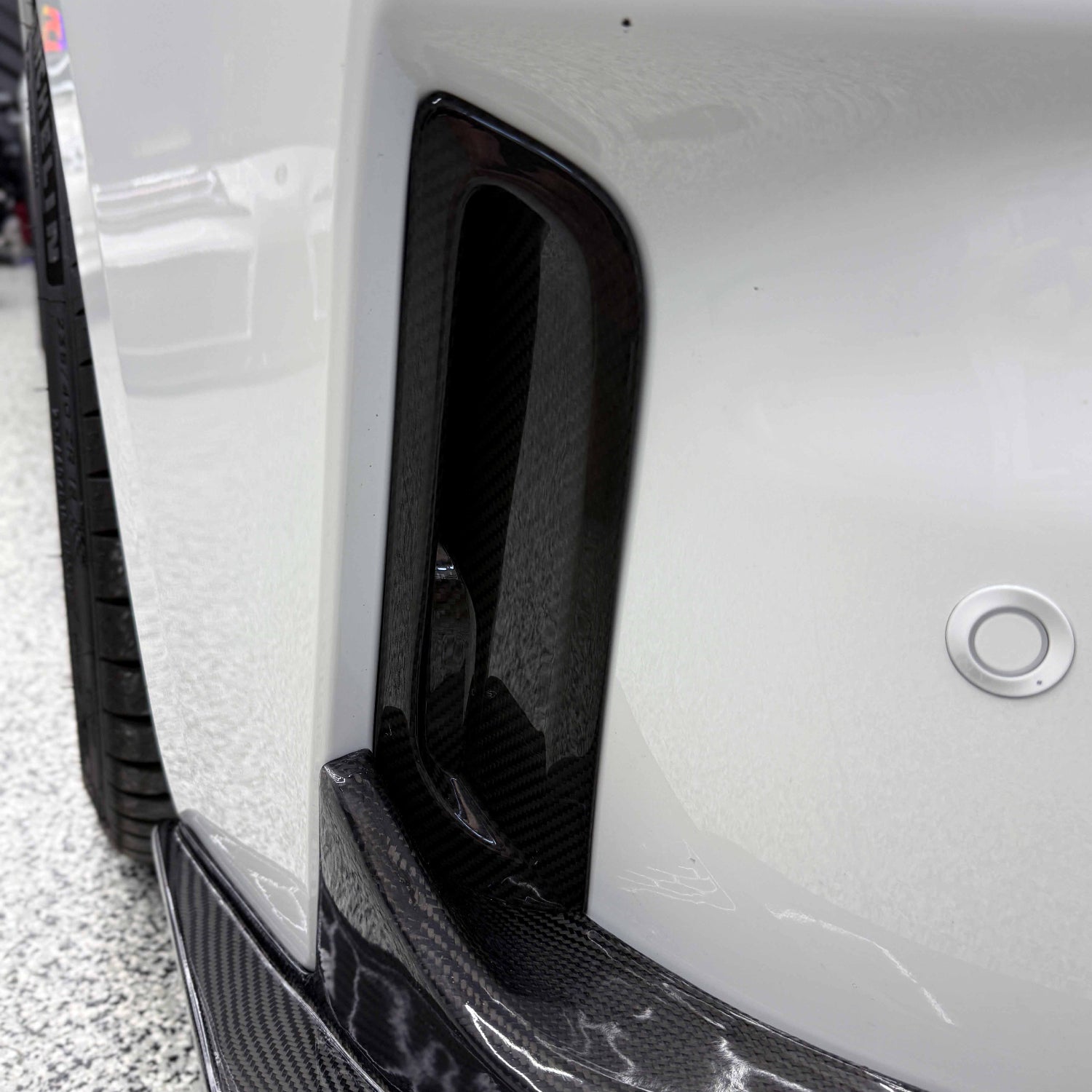Close-up of a white Toyota GR Corolla front bumper air ducts.