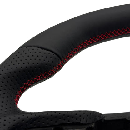 Close-up of a black perforated leather steering wheel rim with red contrast stitching, shown against a white background.