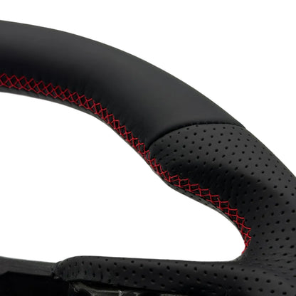 Close-up of a black perforated leather steering wheel rim with red contrast stitching, showing the textured grip and inner structure against a white background.