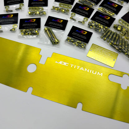 Collection of JDC titanium hardware packages on a white surface with a gold titanium radiator cooling plate.