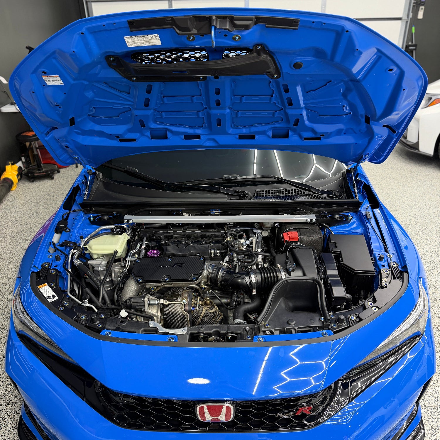 Blue Honda car with open hood showing engine compartment