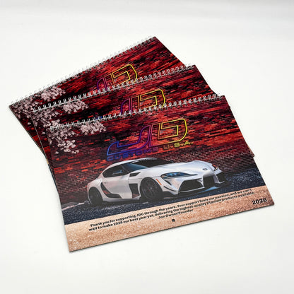 JD Customs USA 2026 Car Calendar cover picture featuring a 2020 Toyota Supra in front of a brick wall background.
