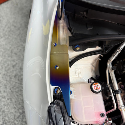 JDC Titanium fender shroud for 2023-2025 Toyota GR Corolla in a burnt gradient finish with matching titanium hardware installed on a white GR Corolla.