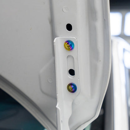Gradient freaktanium titanium hardware installed on a white Acura Integra A-Spec hood bracket
