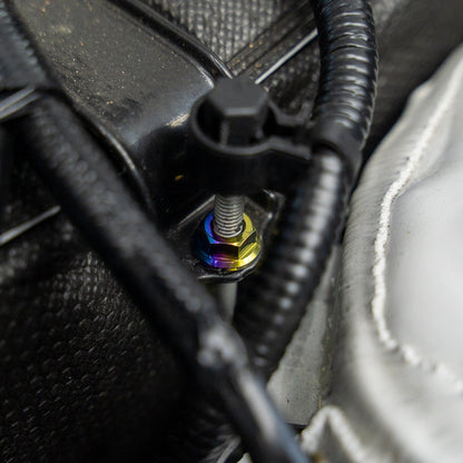 Gradient freaktanium titanium hardware installed on a white Acura Integra A-Spec battery tie down