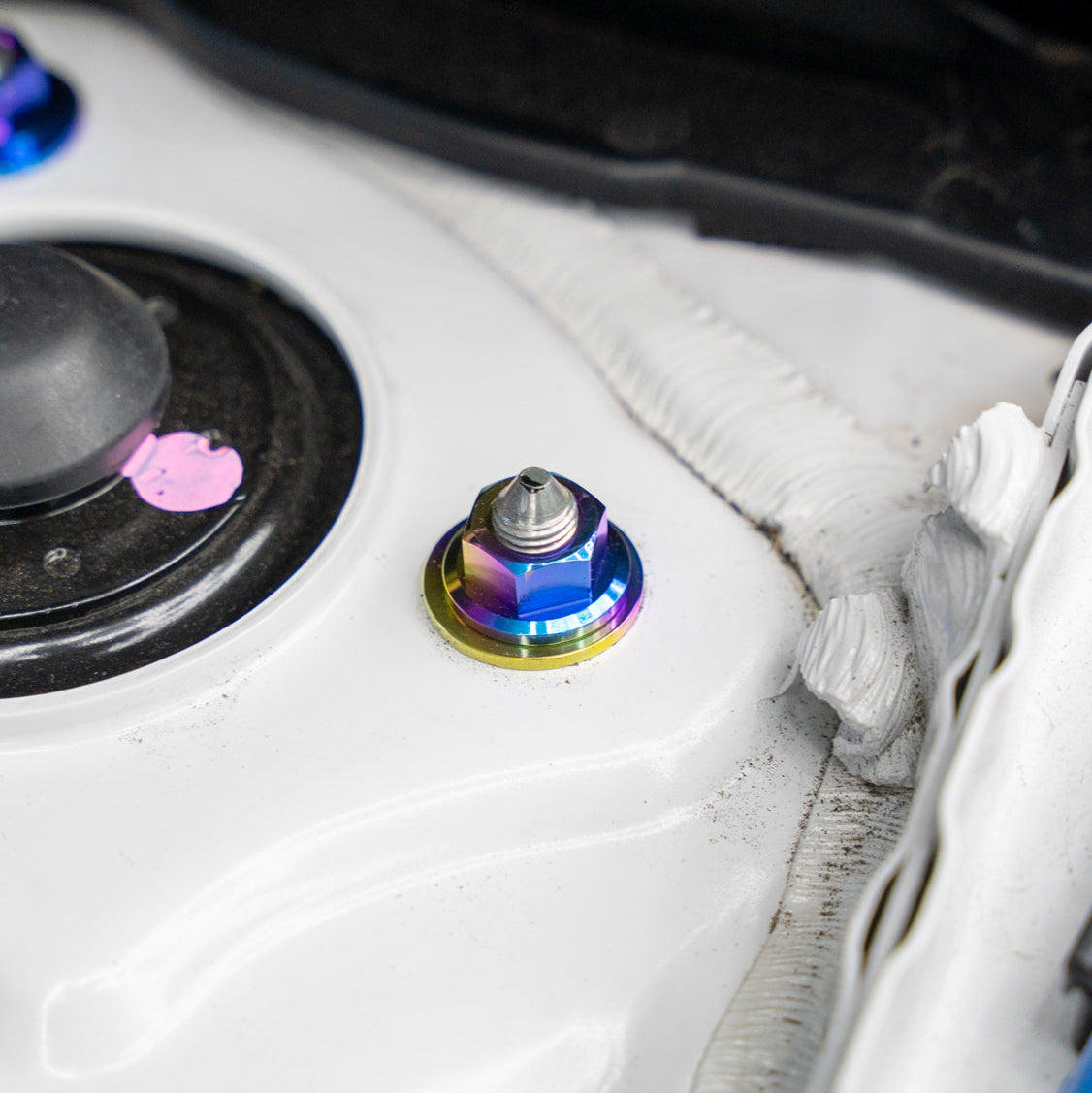 Gradient freaktanium titanium hardware installed on a white Acura Integra A-Spec strut tower