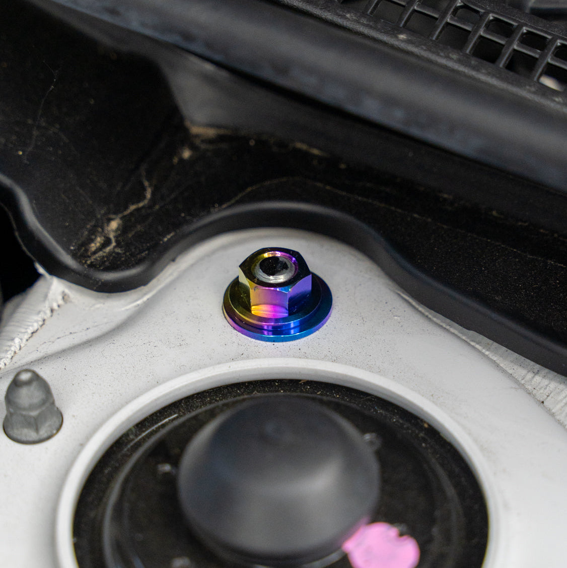 Gradient freaktanium titanium hardware installed on a white Acura Integra A-Spec strut tower