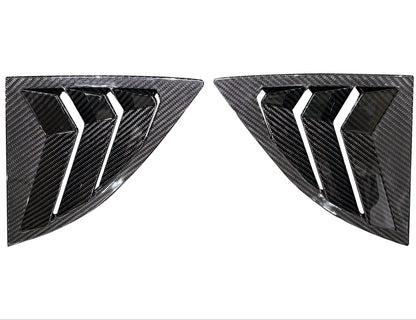 Two carbon fiber car window louvers on a white background