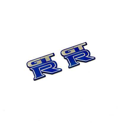 Two blue JDC Titanium Door sill badges for R35 GT-R on a white background.