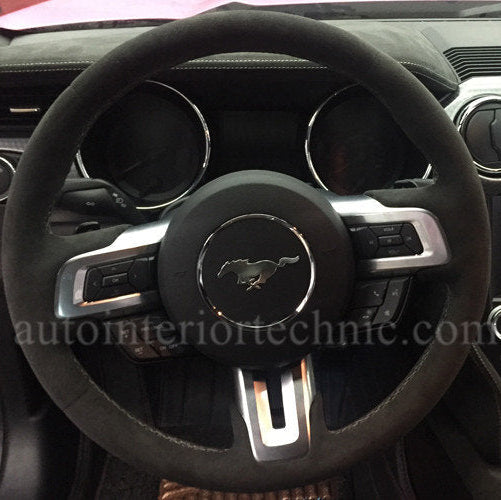 Steering wheel with Ford logo in a car interior with AIT steering wheel wrap.