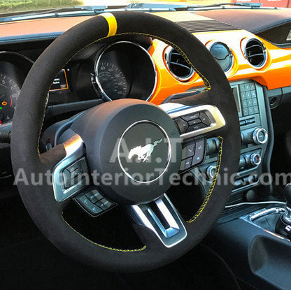Steering wheel with Mustang logo in a car interior, featuring black and yellow accents on the AIT steering wheel wrap.