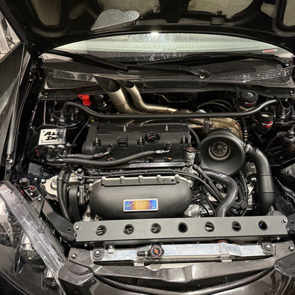 Car engine compartment with visible Skunk2 badge branding JDC titanium badge